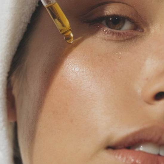 Model applying Citrus Glow Elixir Vitamin C face oil for glowing skin